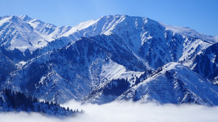 Cordillera nevada entre niebla, metáfora de desafíos complejos.