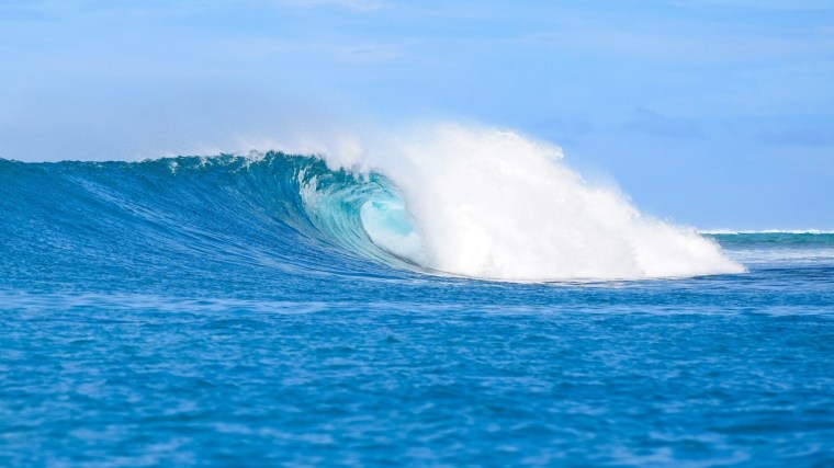 Ola azul formándose, representación de energía y transformación.